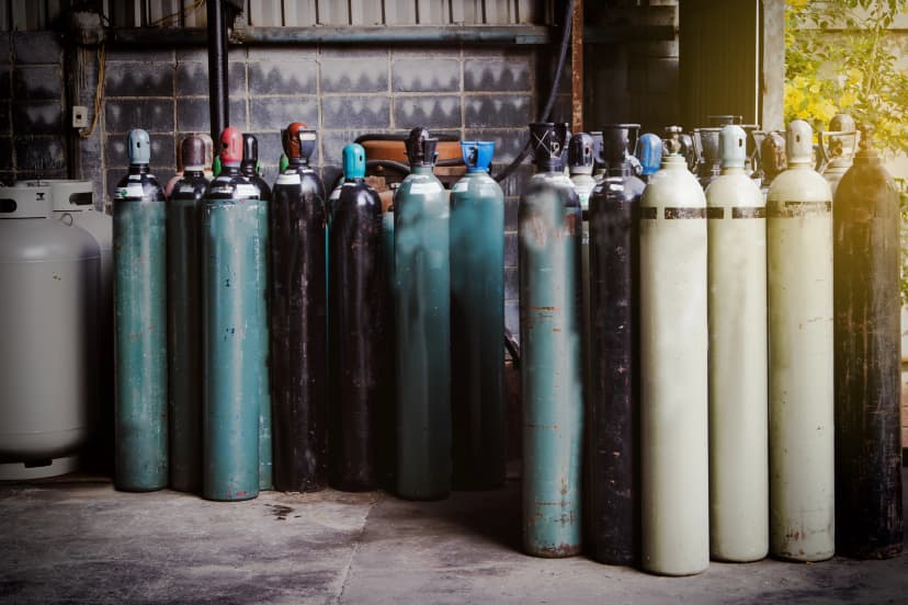 Collection of Oxygen Cylinders Various used oxygen cylinders stored upright in a storage area.